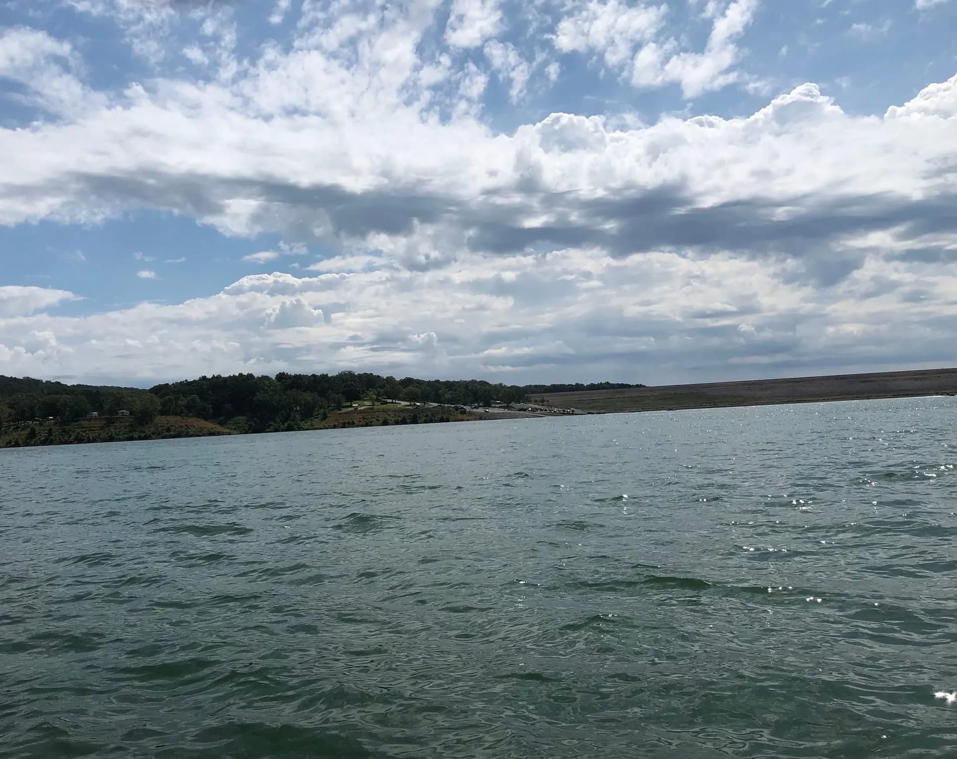 A Southeast Missouri lake under a cloudy sky, with wooded hills on the far shore